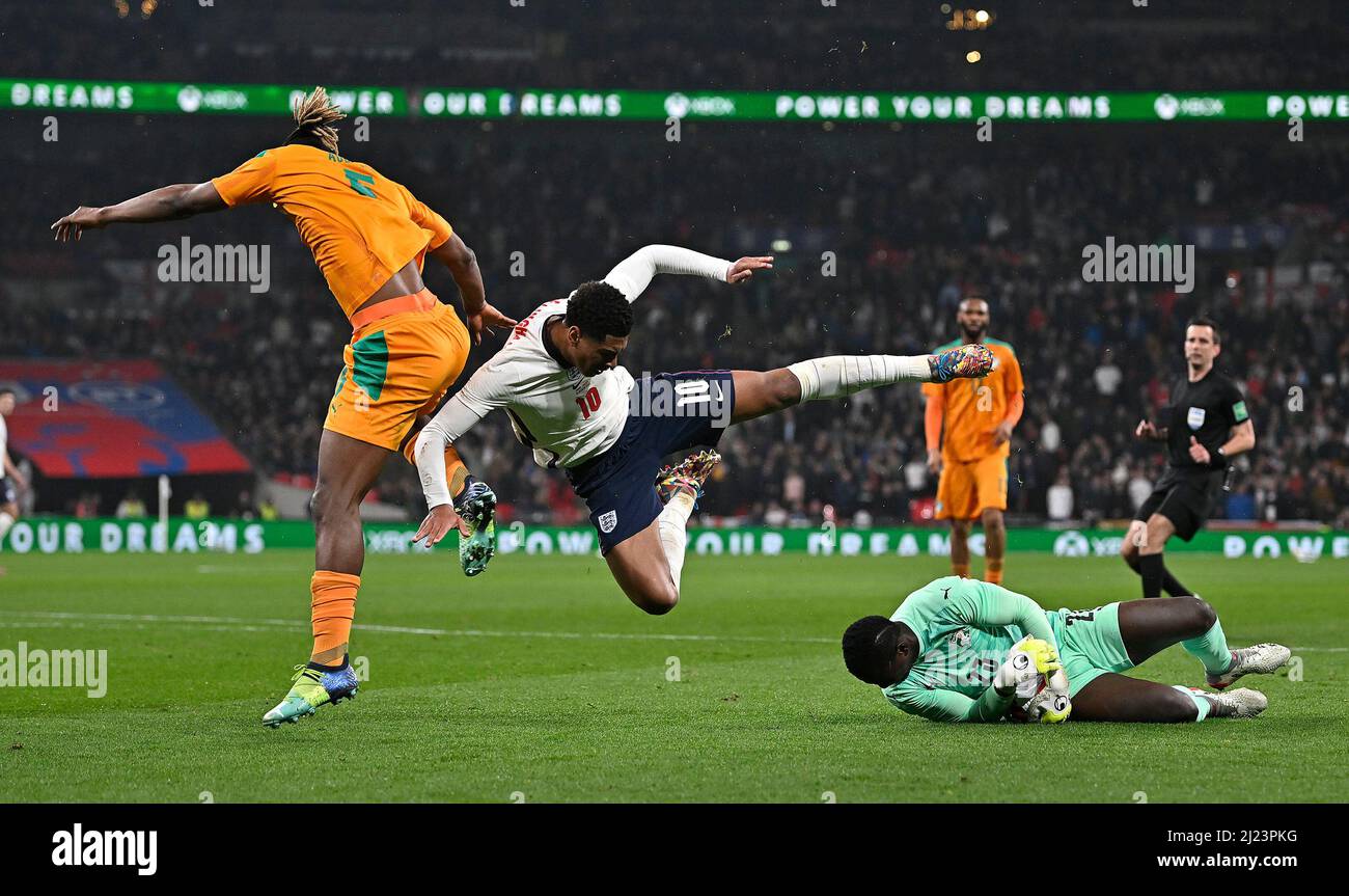 London, UK. 29th Mar, 2022. Badra Ali Sangare (Ivory Coast, goalkeeper) slides out to collect the ball as Jude Bellingham (England) and Emmanuel Agbadou (Ivory Coast) jumpover during the International Friendly match between England and Ivory Coast at Wembley Stadium on March 29th 2022 in London, England. (Photo by Garry Bowden/phcimages.com) Credit: PHC Images/Alamy Live News Stock Photo