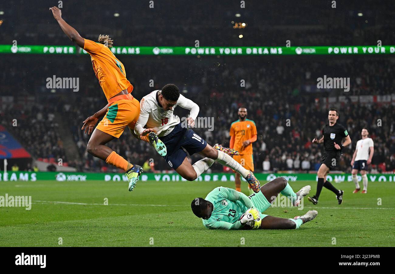 London, UK. 29th Mar, 2022. Badra Ali Sangare (Ivory Coast, goalkeeper) slides out to collect the ball as Jude Bellingham (England) and Emmanuel Agbadou (Ivory Coast) jumpover during the International Friendly match between England and Ivory Coast at Wembley Stadium on March 29th 2022 in London, England. (Photo by Garry Bowden/phcimages.com) Credit: PHC Images/Alamy Live News Stock Photo