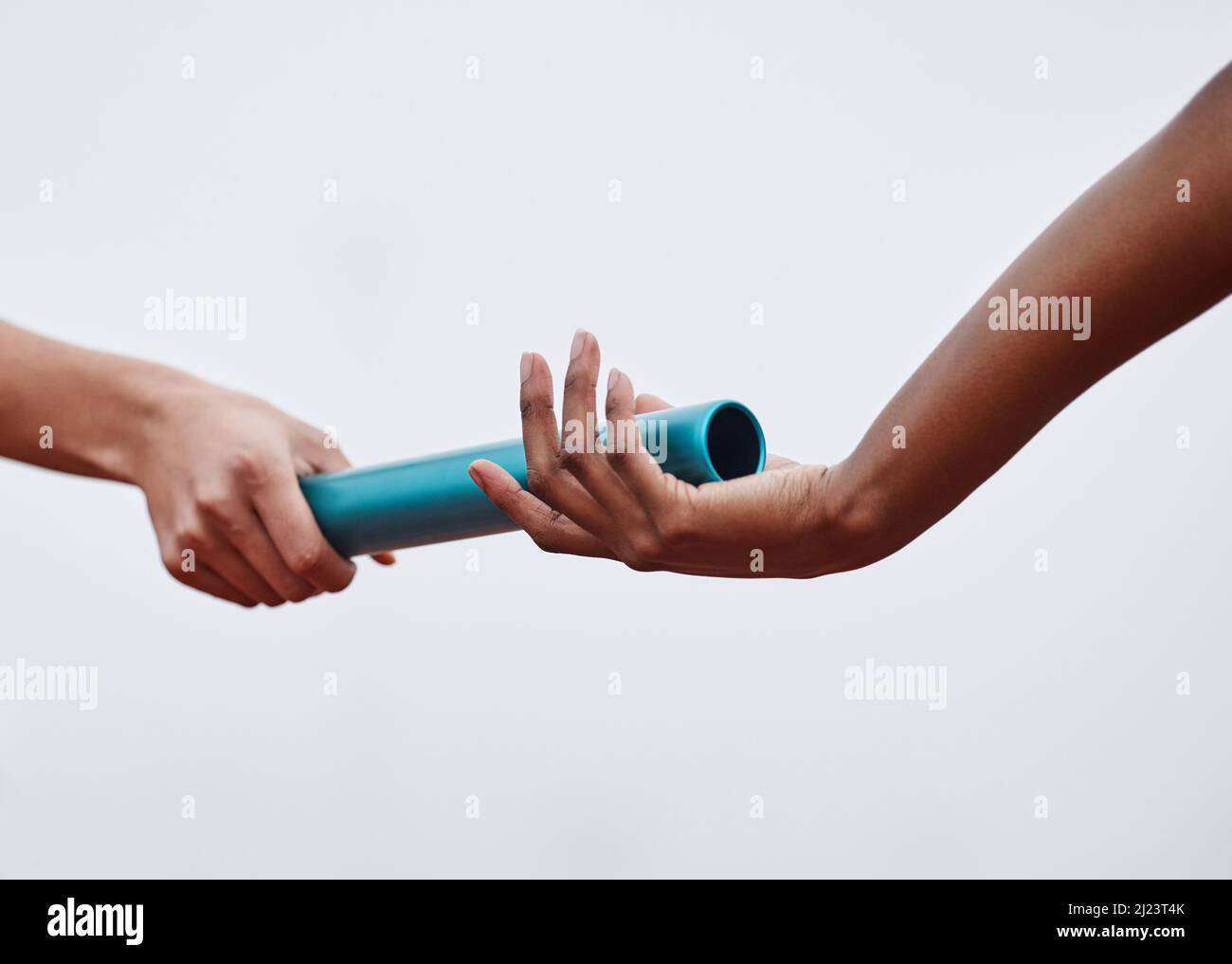 Nothing will stop us now. Shot of two athletes passing a baton during a relay race Stock Photo