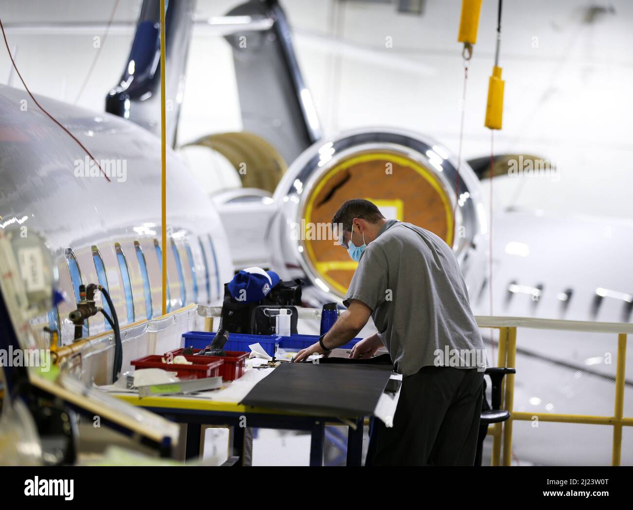 A Bombardier employee works on interior completions and exterior touchups for delivery