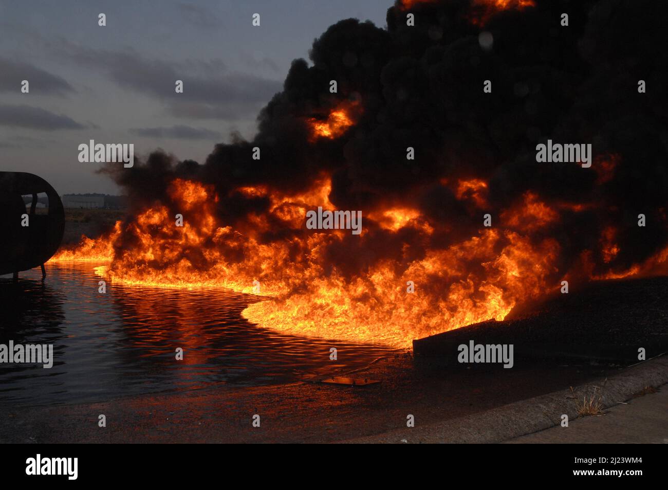 Flames spread in the fire pit aboard MCAS Miramar during a training evolution. Stock Photo