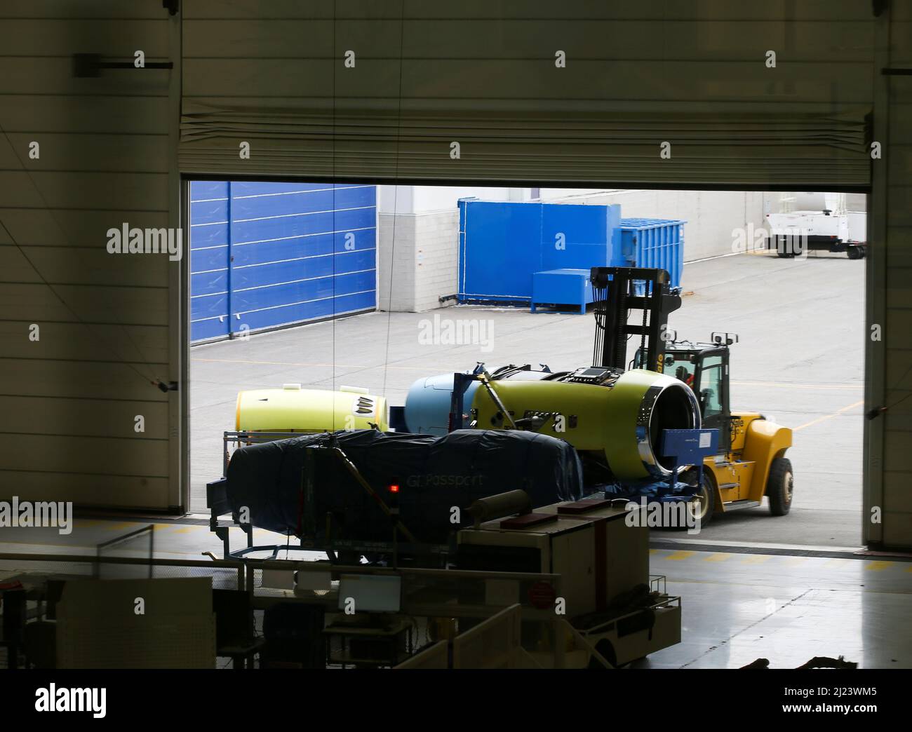 An engine is brought into a bay where Bombardier employees work on interior completions and