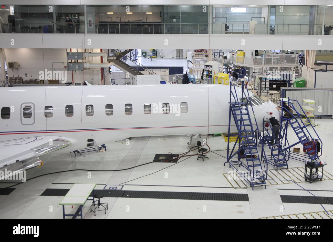 Bombardier employees work on interior completions and exterior touchups for delivery