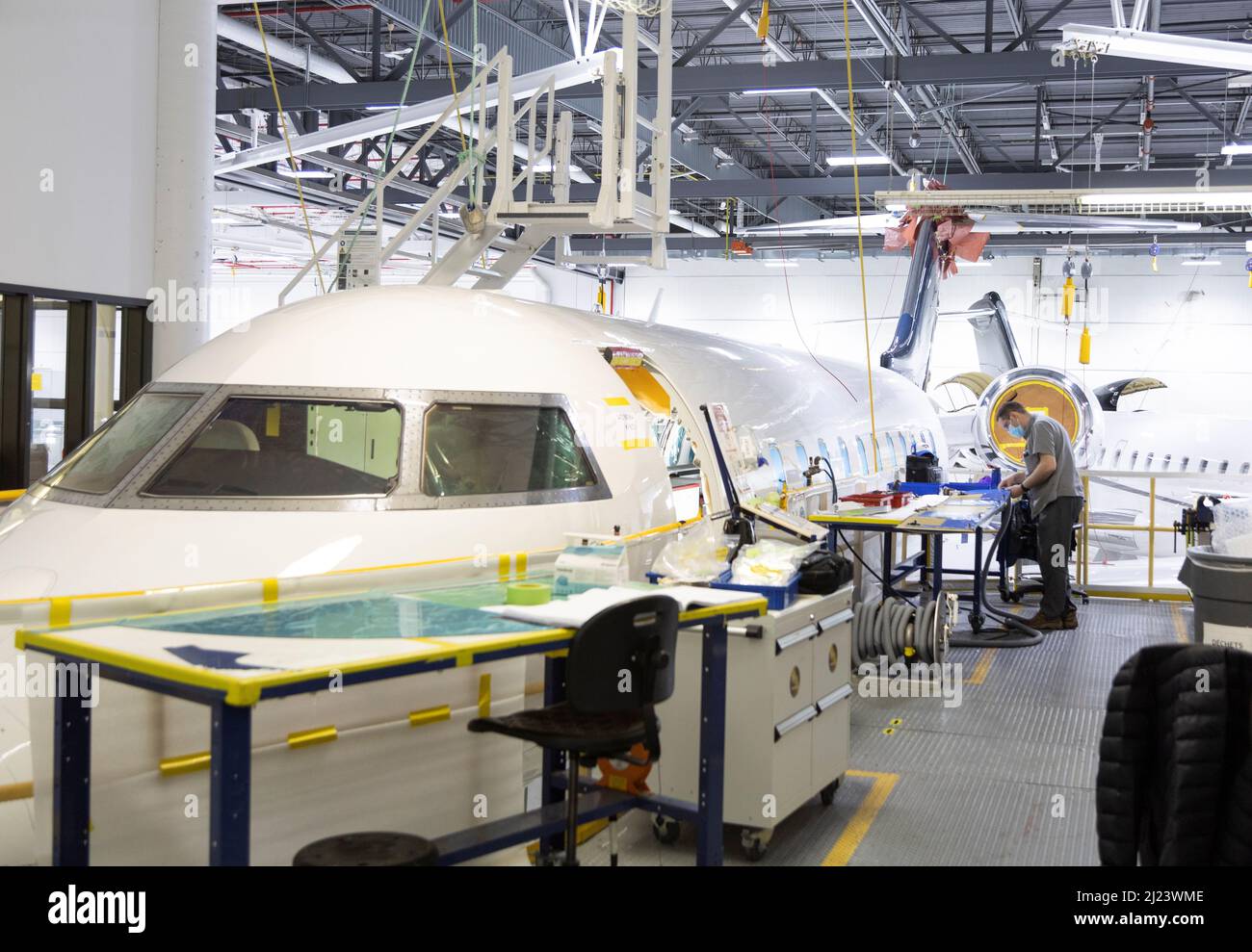 A Bombardier employee works on interior completions and exterior touchups for delivery