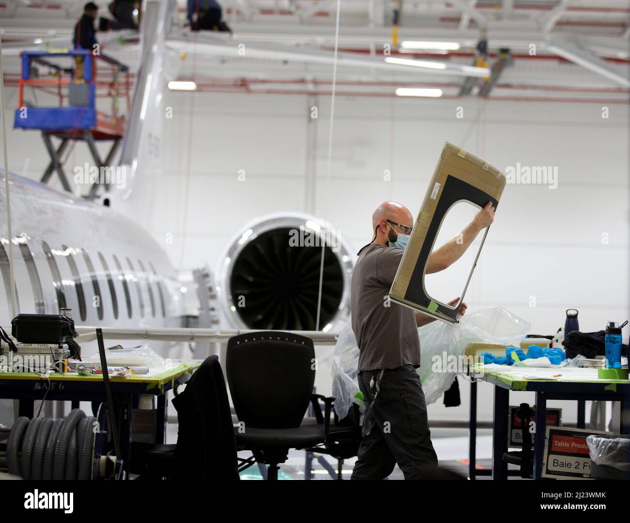 A Bombardier employee works on interior completions and exterior touchups for delivery