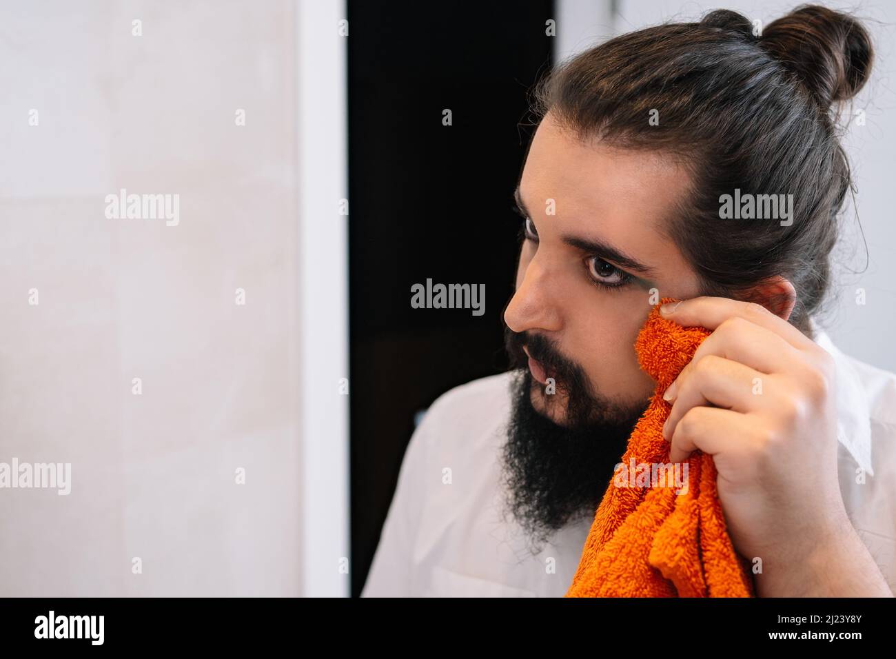young man, touching up his eye make-up with a towel Stock Photo