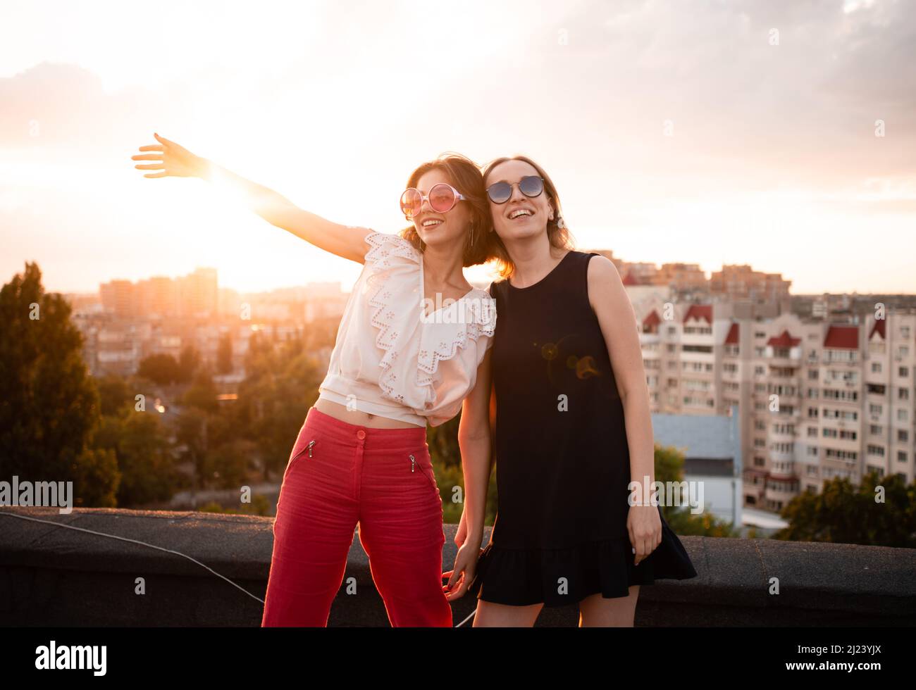 two friends on roof on sunset Stock Photo