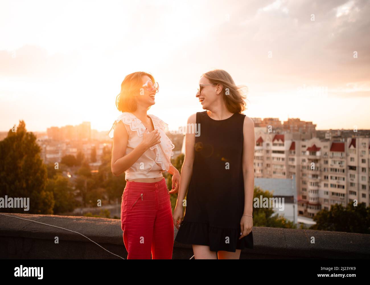 two friends on roof on sunset Stock Photo