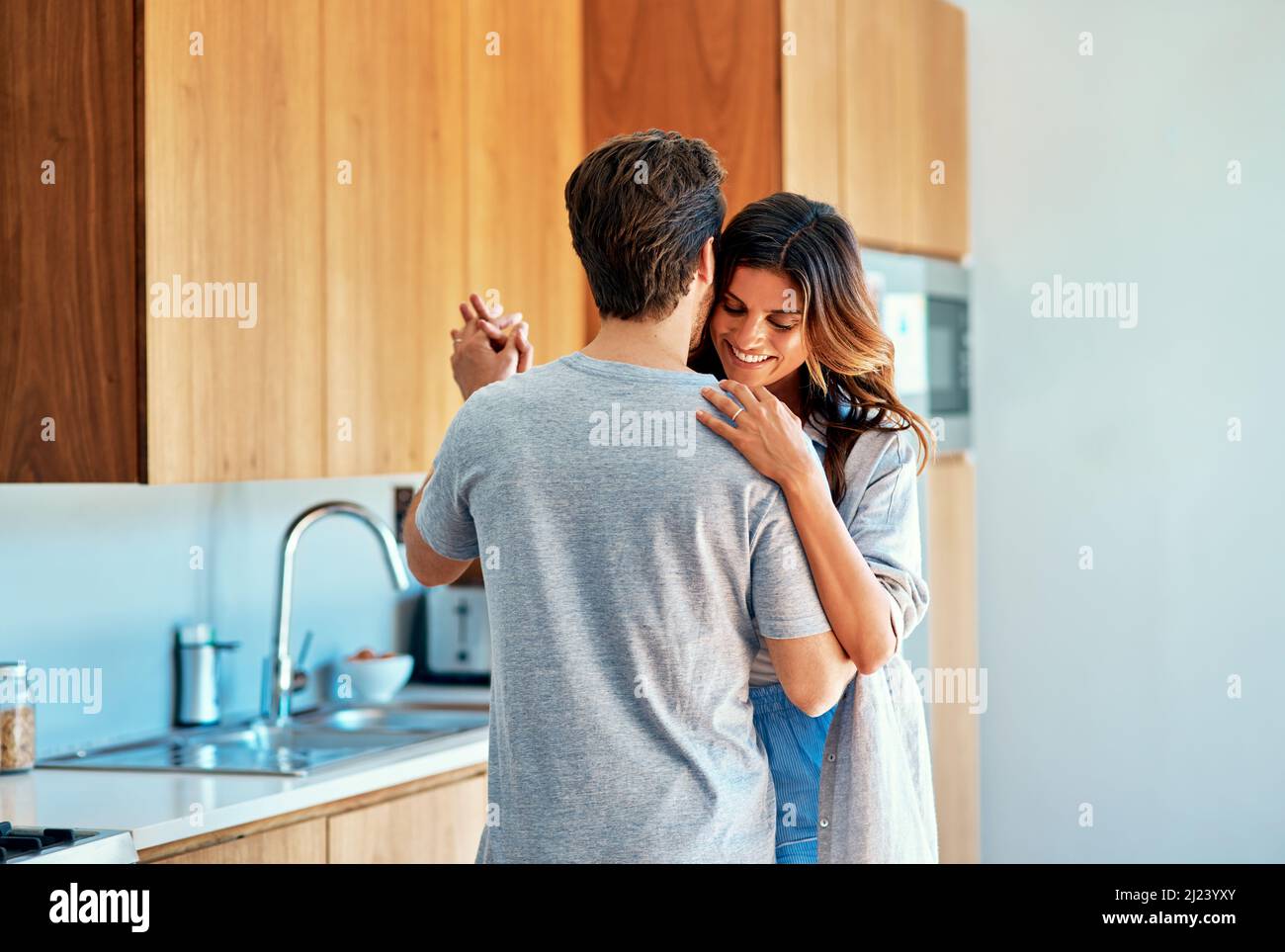 Theyve got that bond that warms all emotion. Shot of an affectionate young couple dancing together at home. Stock Photo