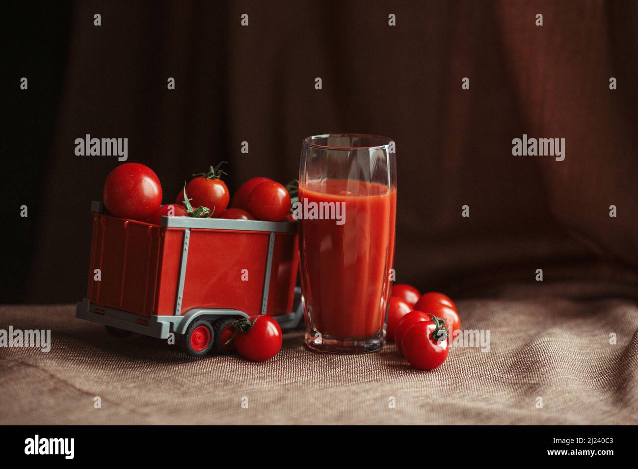 tomatoes in a toy trailer tomato juice in a glass Stock Photo