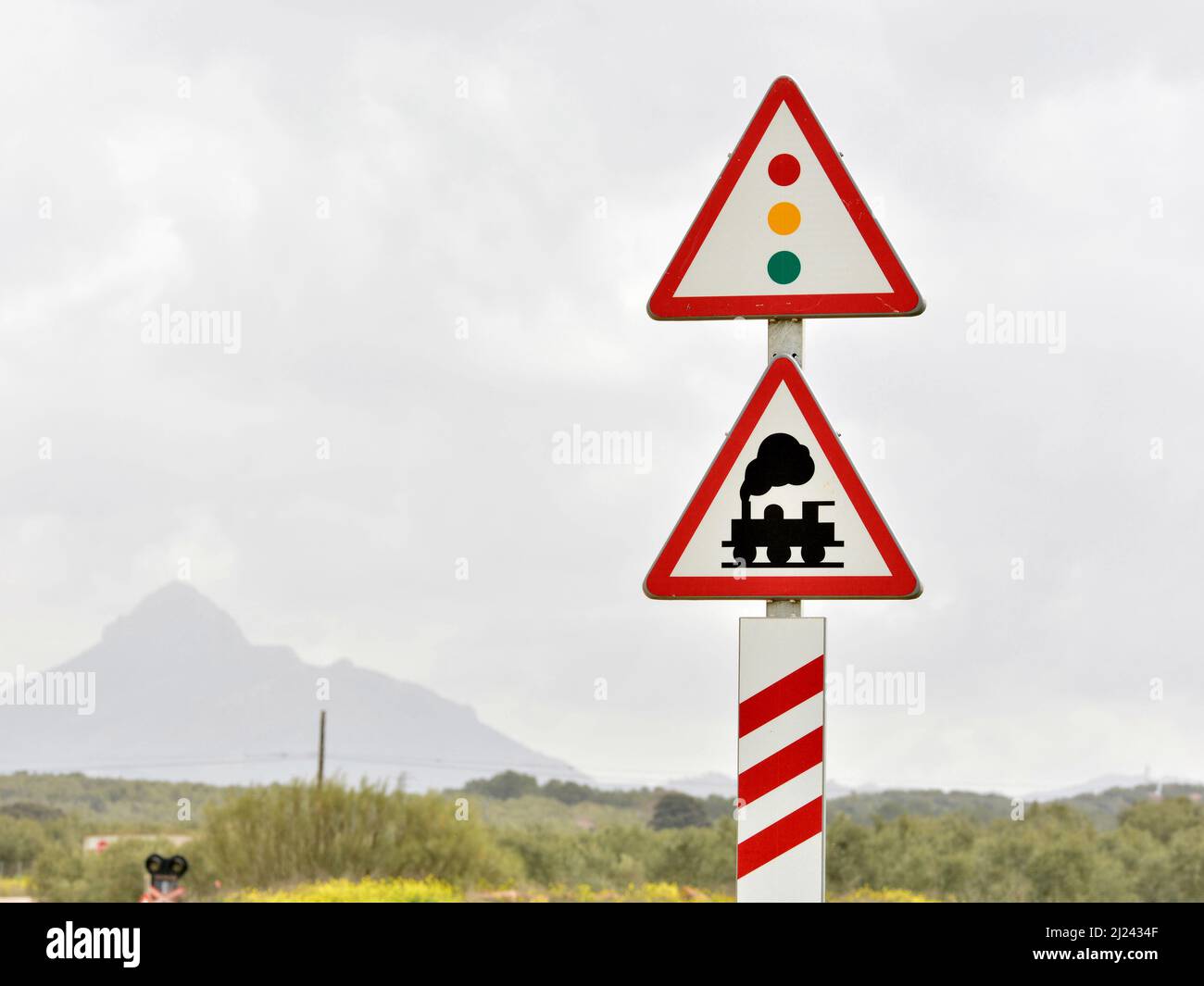 Paisaje con señales de peligro, de paso a nivel sin barrera y semáforo Stock Photo