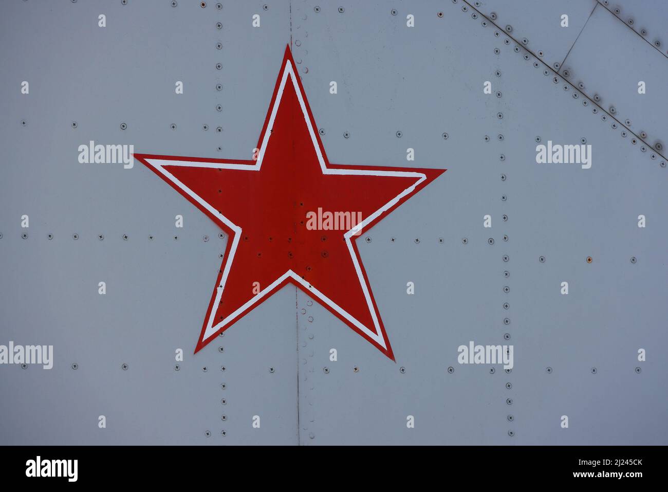 Close up Soviet Union or Russian red star symbol painted on vintage military fighter aircraft studded metal surface Stock Photo