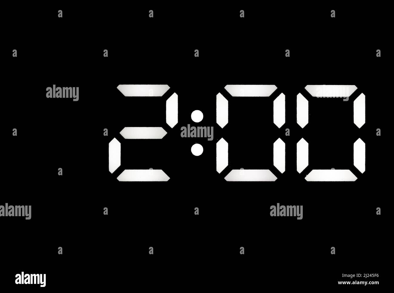 Real white led digital clock on a black background showing time 2:00 Stock Photo