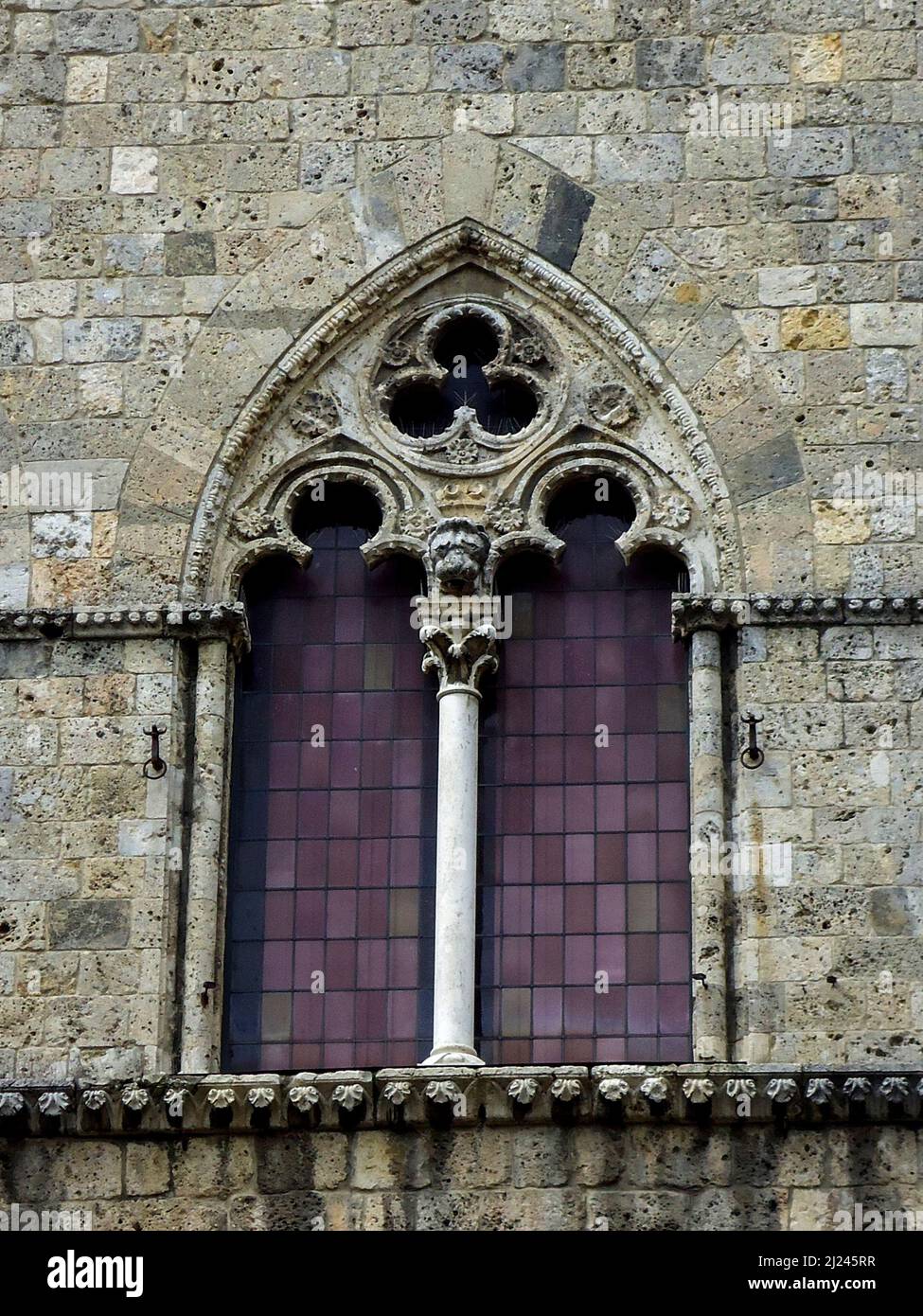 Medieval Gothic bifora window with ornate stone carvings in Italy Stock ...