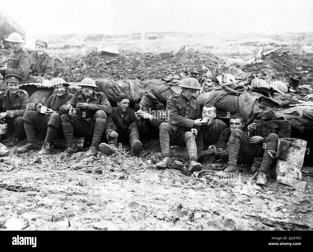 Soldiers of the Canadian Expeditionary Force, possibly 25th Battalion (Nova Scotia Rifles) of the 5th Infantry Brigade, 2nd Infantry Division eating rations whilst seated on muddy ground outside a shelter near Pozieres, October 1916, during the final stages of the Battle of the Somme, possibly during the Battle of Le Transloy. Stock Photo