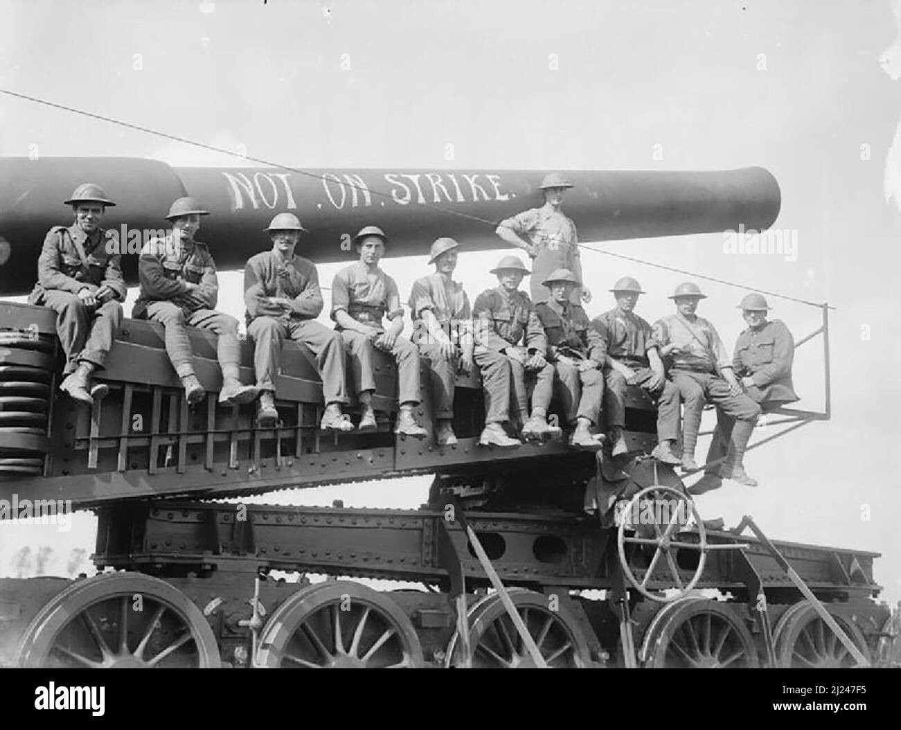 1917 Battle of Langemarck 16-18 August: 12 inch railway gun at Woesten with its crew perched on it and the slogan 'Not on Strike' on the barrel. NOTE : The pattern of the bogie wheels with the frame inside identifies this as a 12 inch Railway Gun on Vickers Mk I mounting. Stock Photo