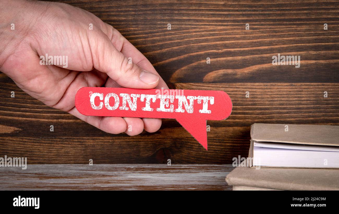 Content. Red speech bubble in a man's hand. Stock Photo