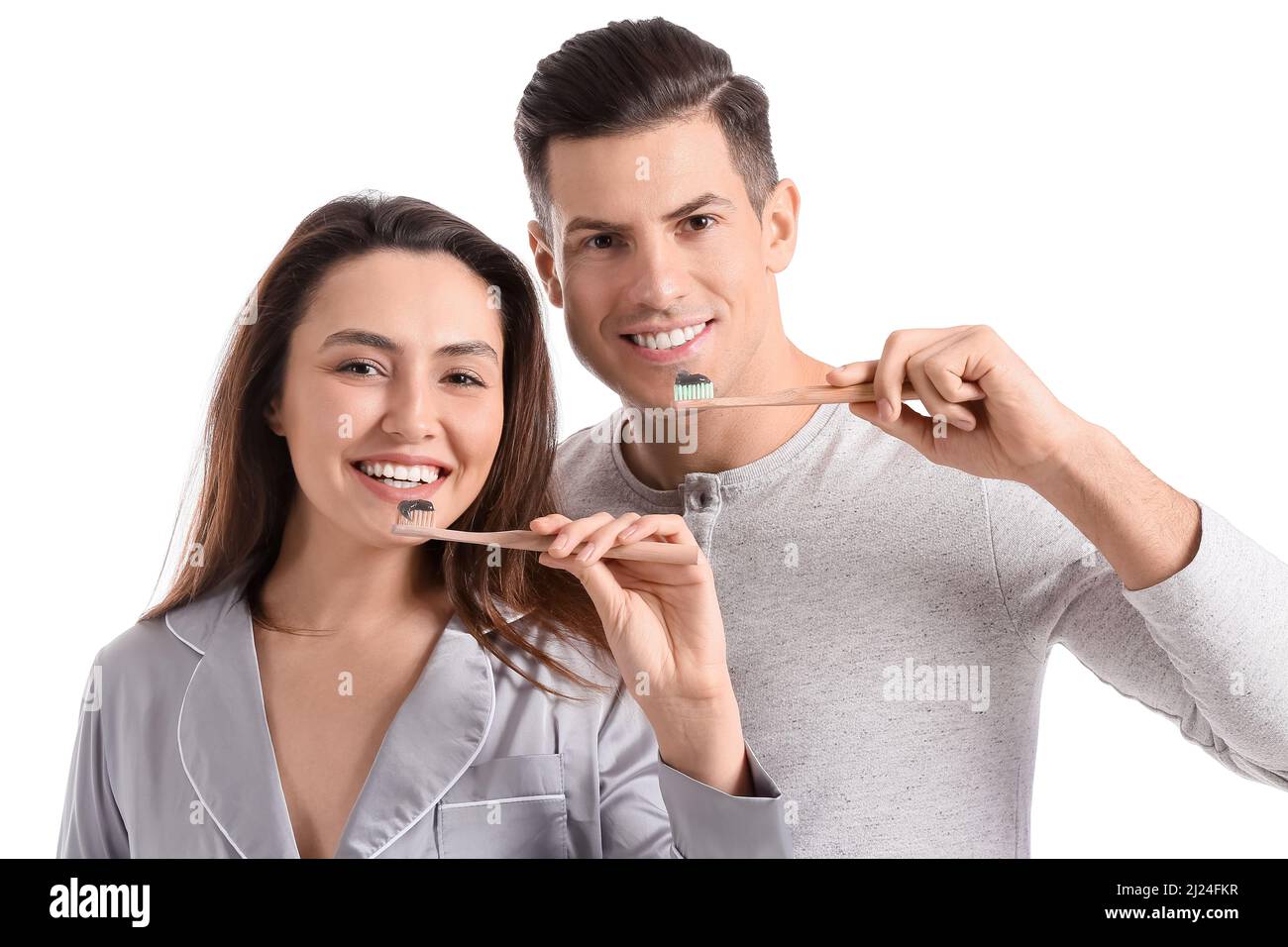 Young couple brushing teeth with activated charcoal tooth paste on ...