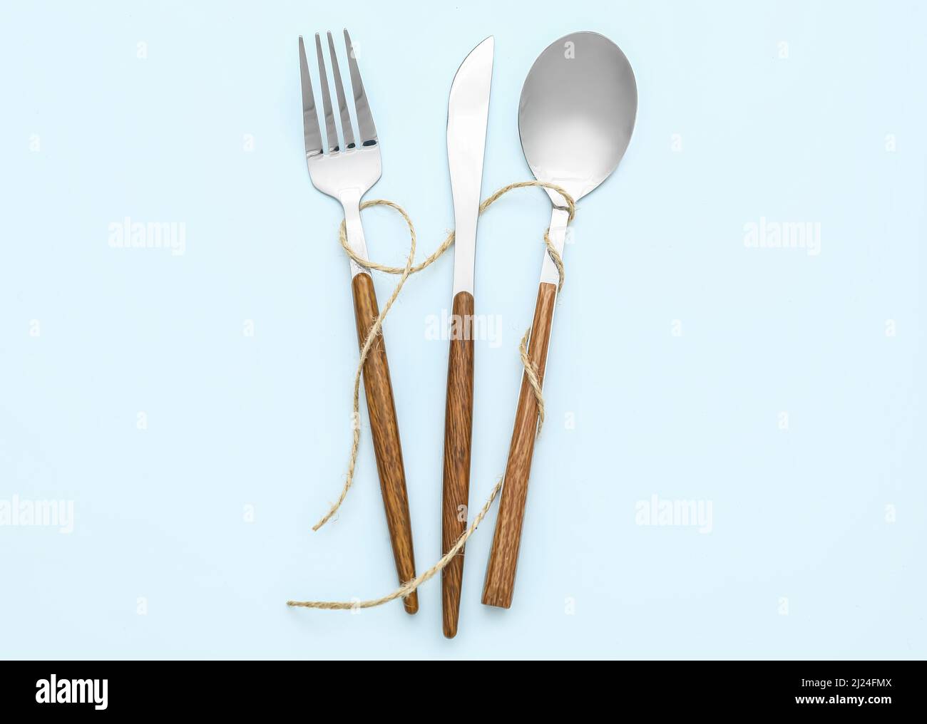 Elegant cutlery with rope on blue background Stock Photo - Alamy