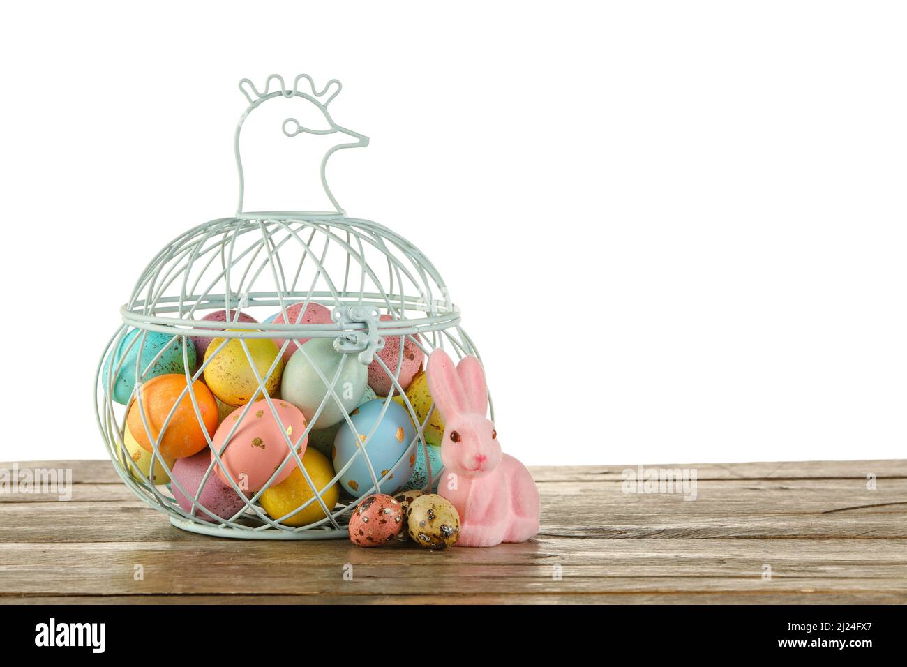 Basket of painted Easter eggs and toy bunny on table against white ...
