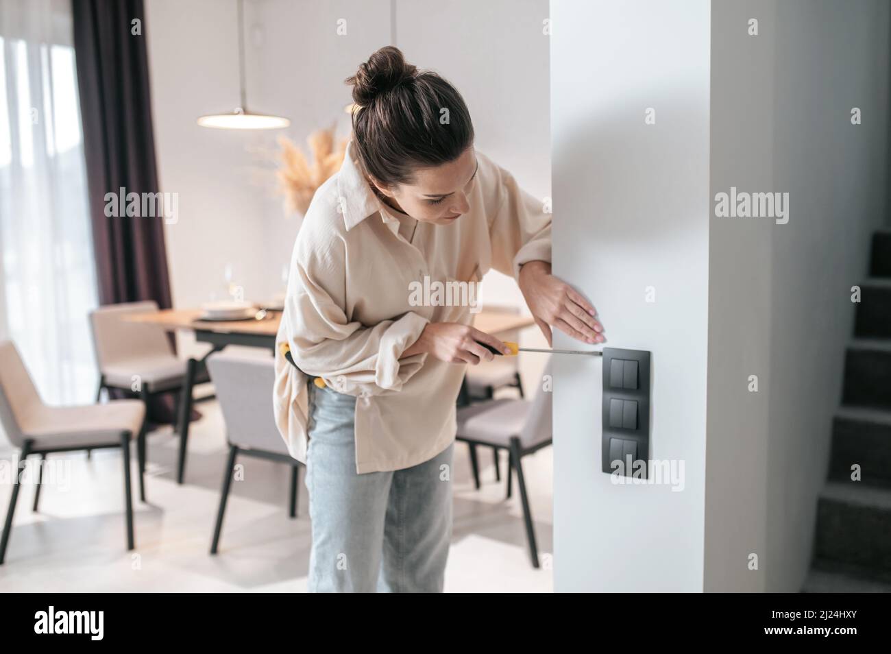 A young woman checking the power socket and looking involved Stock ...