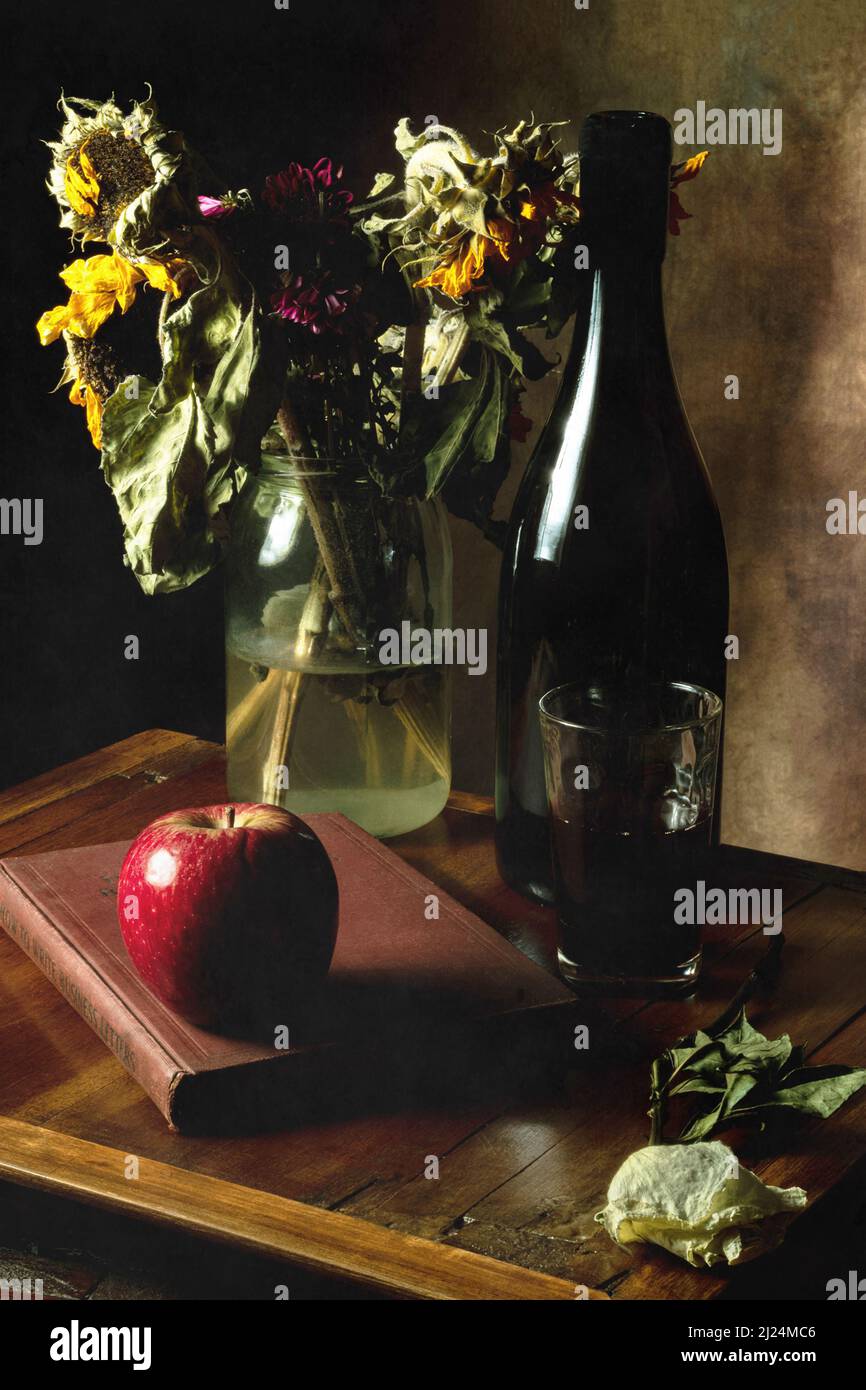 Still Life of book, apple, dried flowers and red wine. Stock Photo