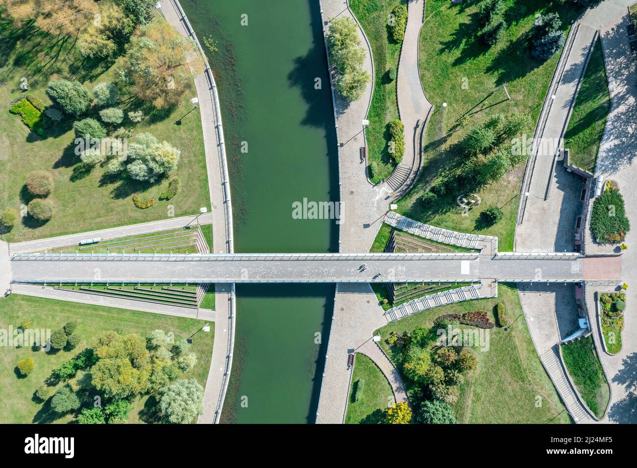 walking bridge in the summer park across the river. aerial top view. Stock Photo
