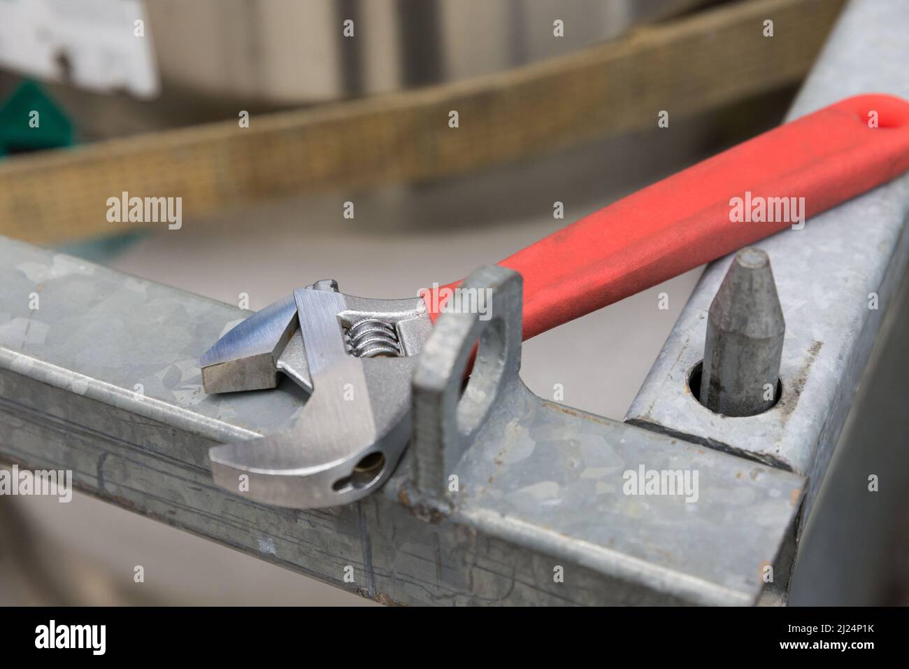 one wrench with red holder lying on metal structure Stock Photo