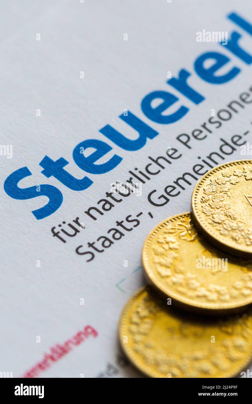 six golden coins on paper of Swiss tax declaration form, Canton of Zurich Stock Photo