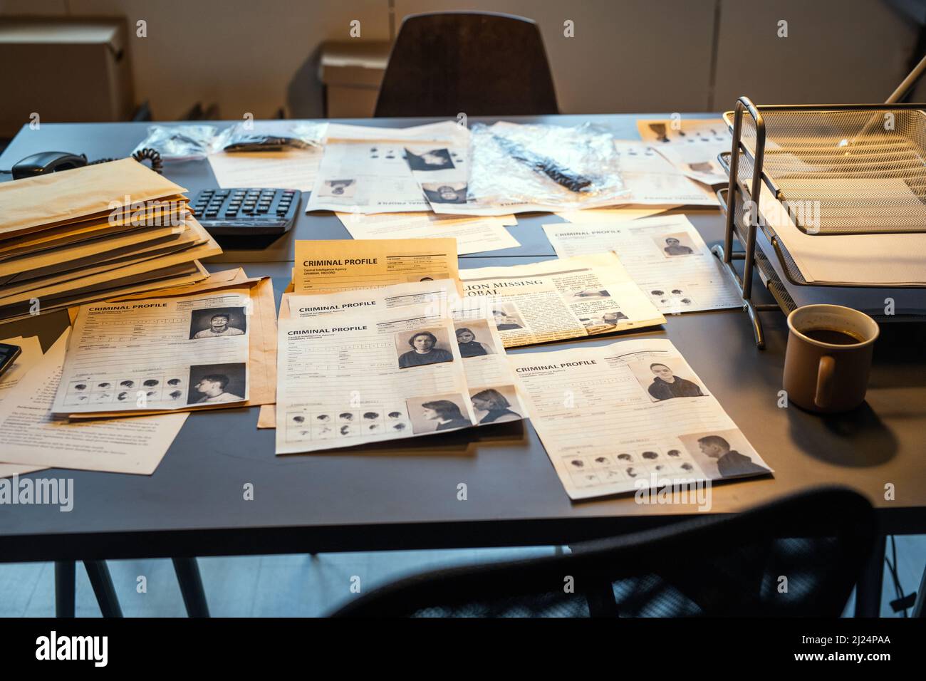 Workplace of fbi agent with criminal profiles, evidences and clues, stacks of packed documents or journals with information Stock Photo