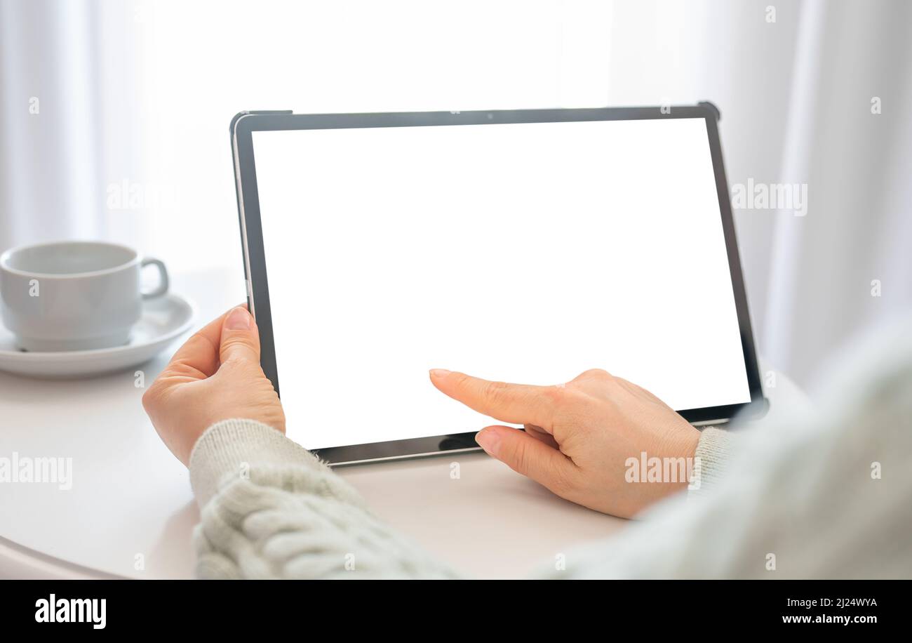 Mockup tablet. Woman hand touch tablet with blank empty screen. Video conference. Online communication. Modern technology. watching video or webinar Stock Photo