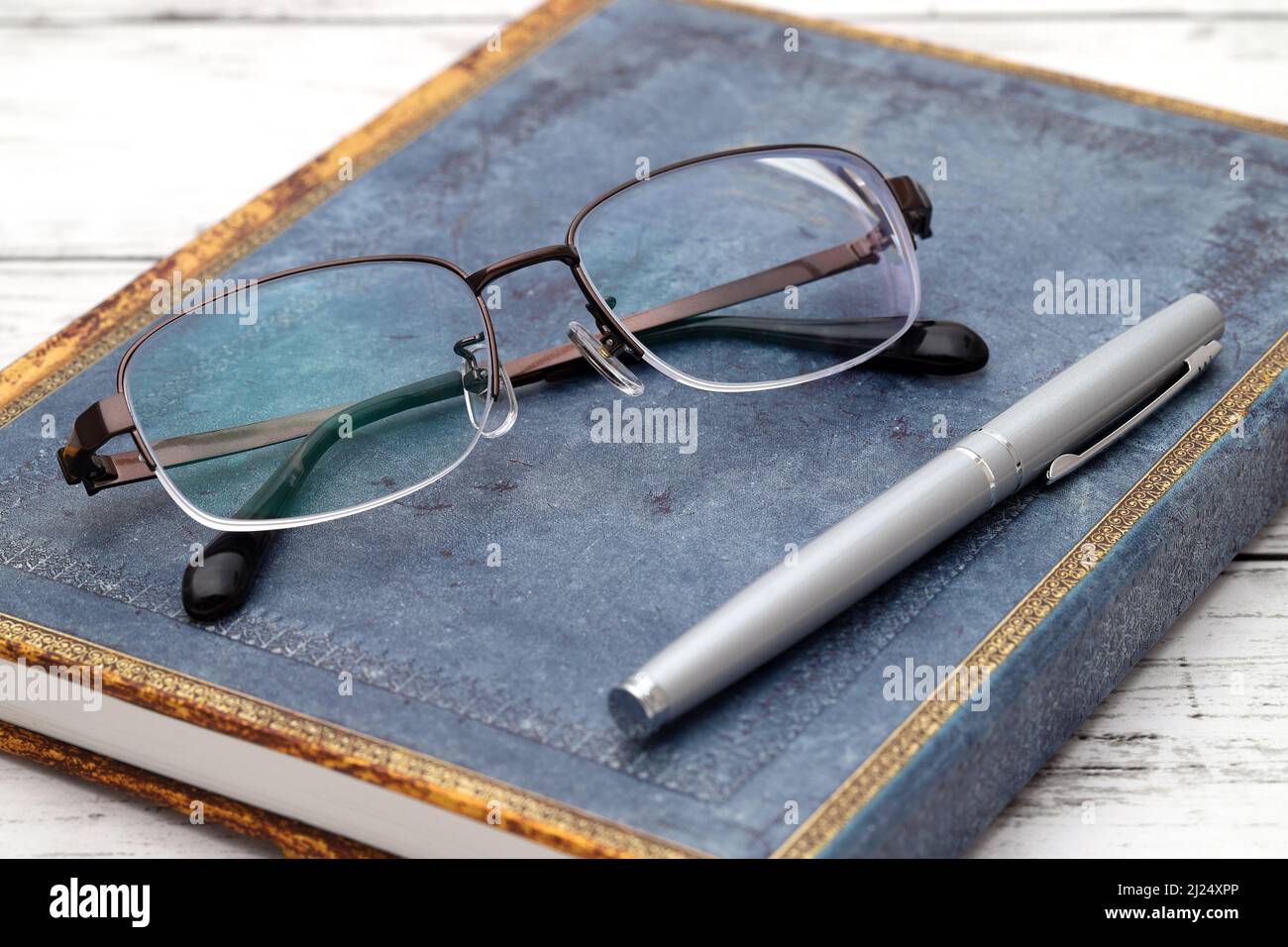 Stylish eyesight glasses and diary book on white wooden table Stock Photo