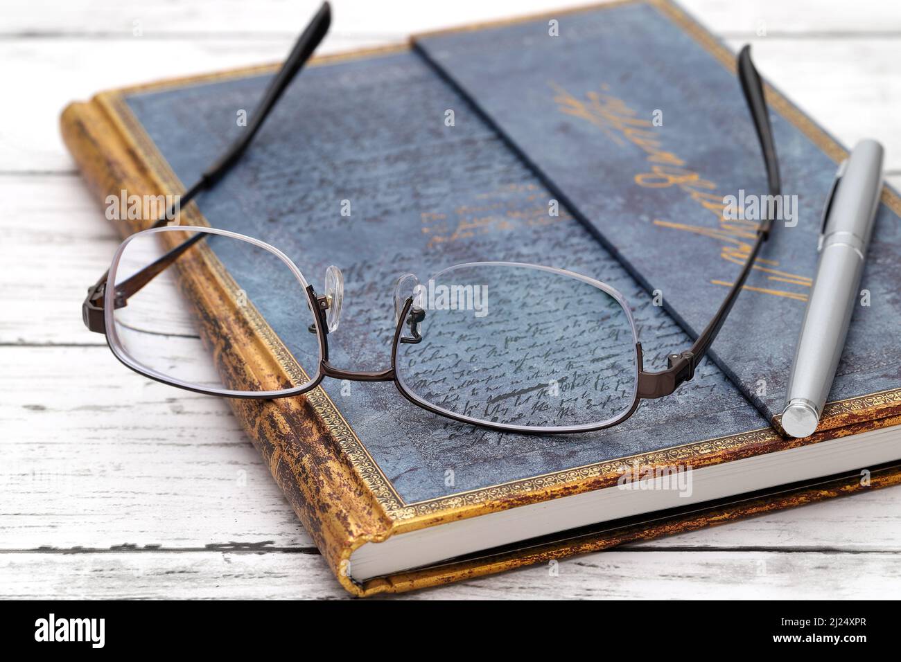 KAGAWA, JAPAN - March 24, 2022 - Stylish eyesight glasses and diary book on white wooden table. Stock Photo