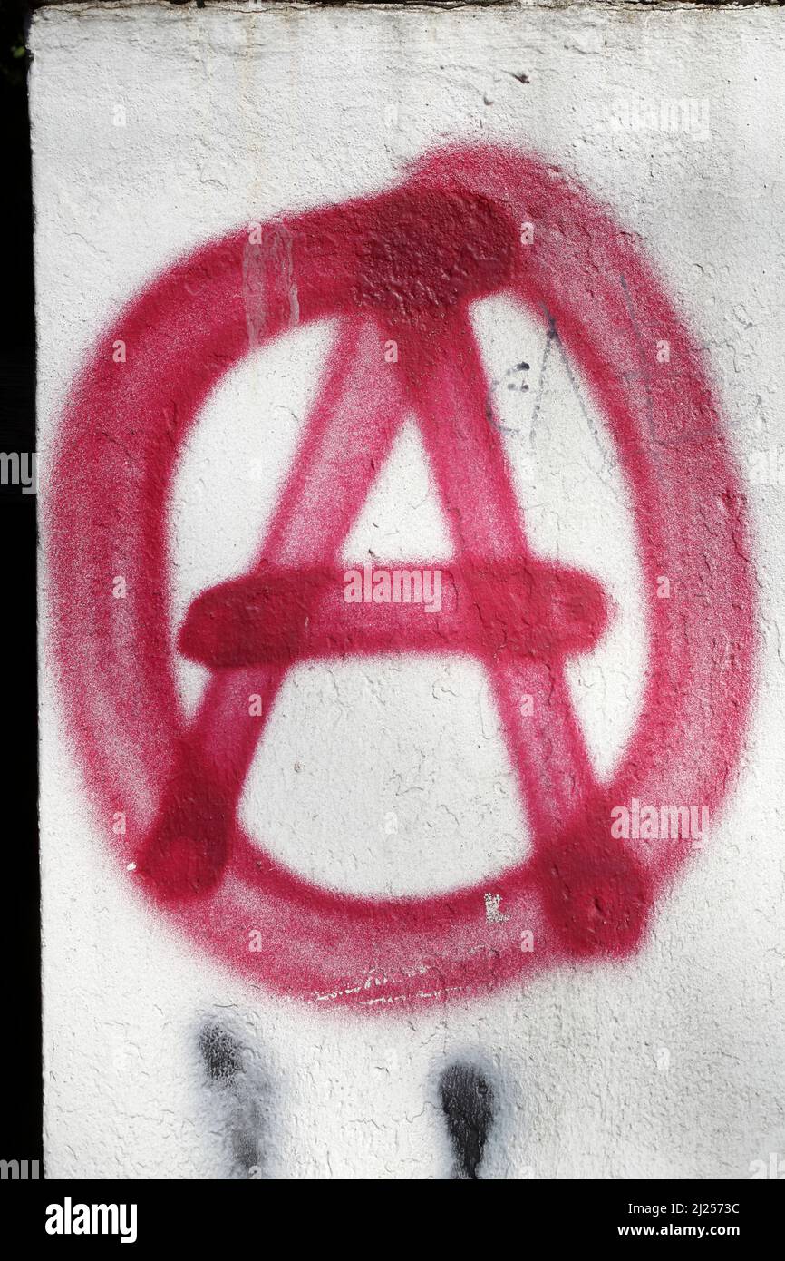 Red A for anarchy painted on white garden wall Stock Photo