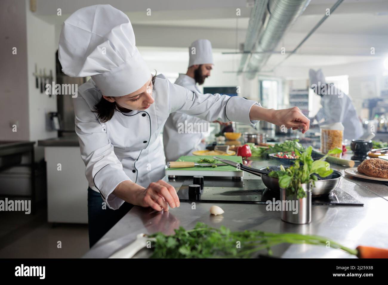 Premium Photo  Food industry worker preparing ingredients for evening meal  in professional kitchen. head chef seasoning gourmet dish in pan while  cooking fine dining food served at dinner service in restaurant.