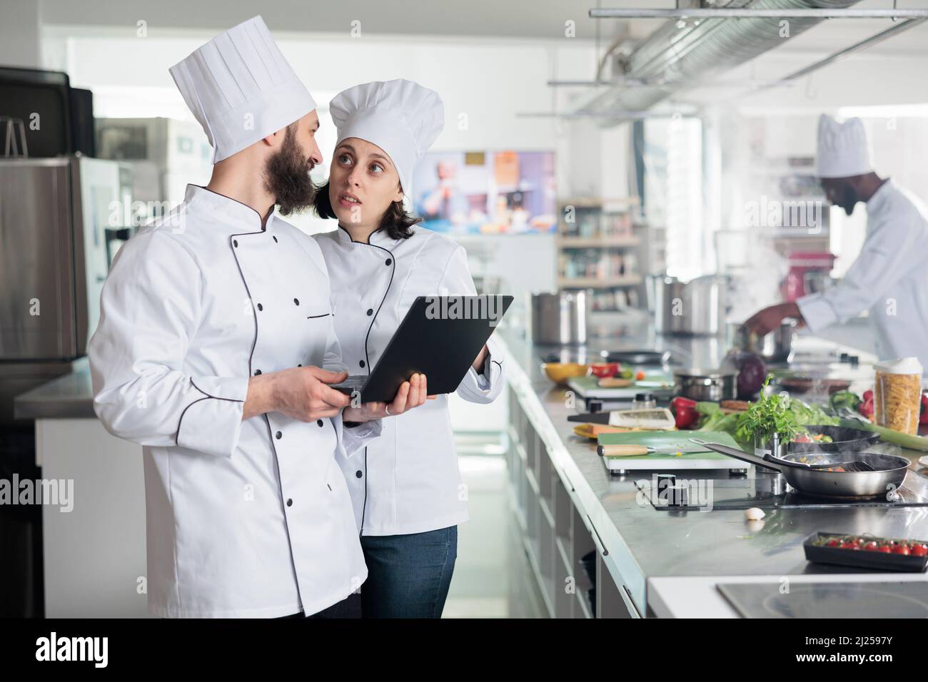 Food industry workers standing in restaurant professional kitchen while