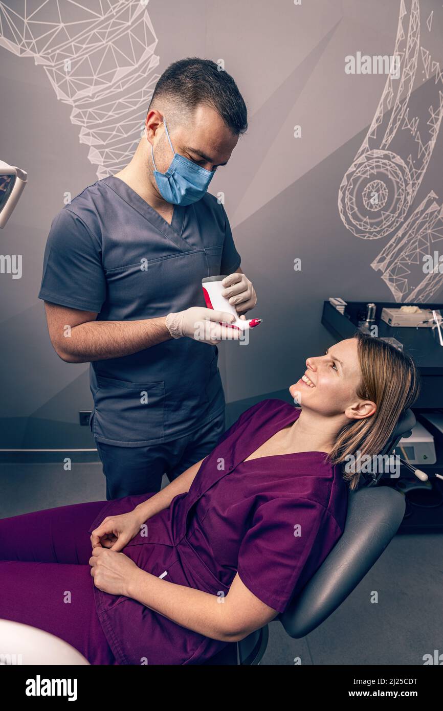 Dentist selecting patients teeth color with digital shade guide teeth