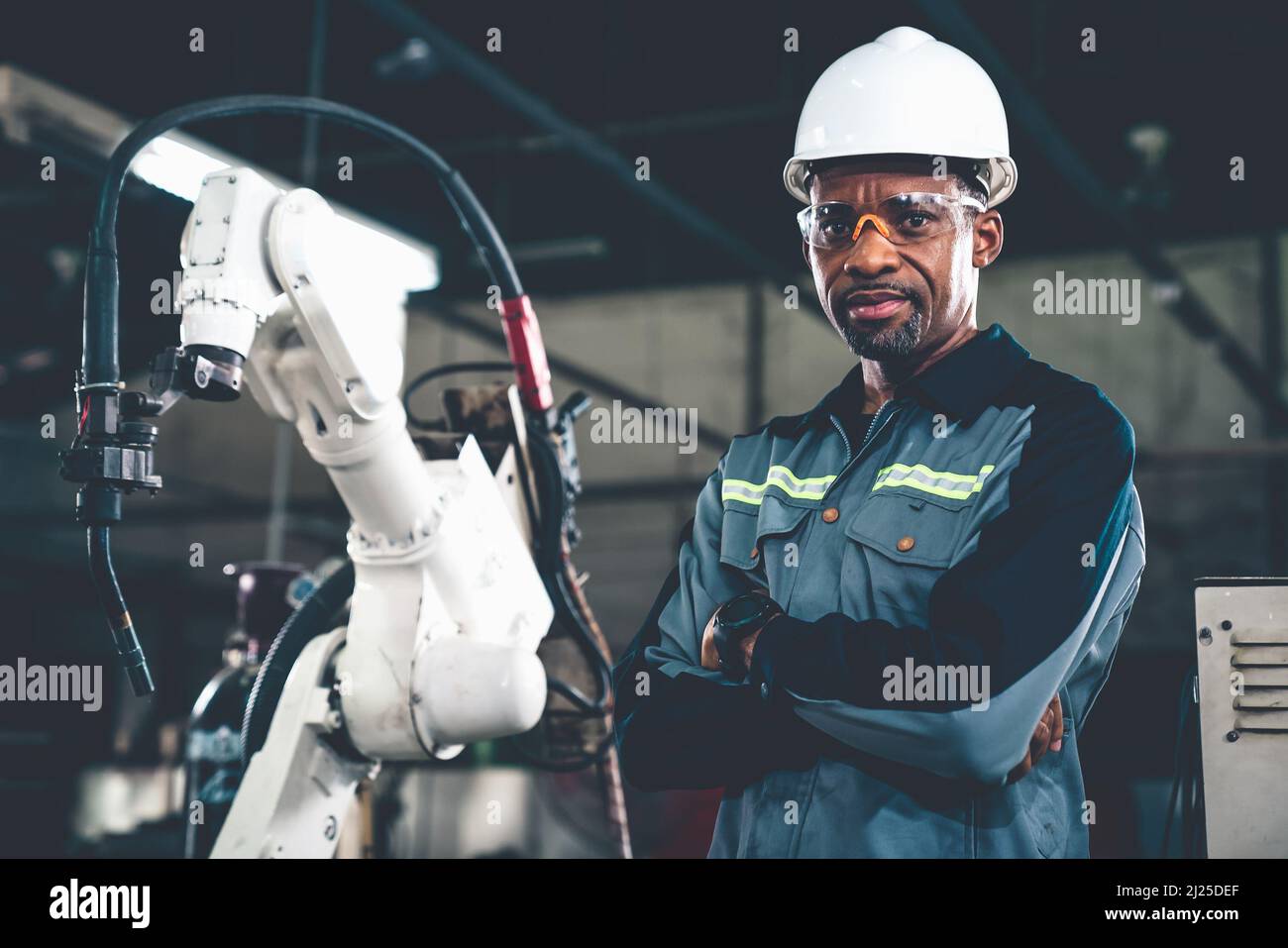 African American factory worker working with adept robotic arm in a