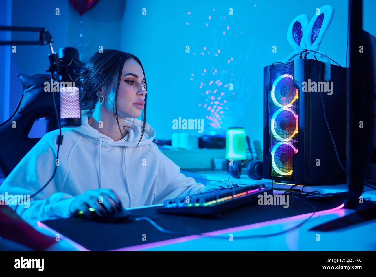 Happy woman putting on headphones and playing computer game. Female