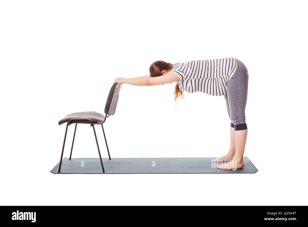 Pregnant woman doing yoga asana Uttanasana Stock Photo