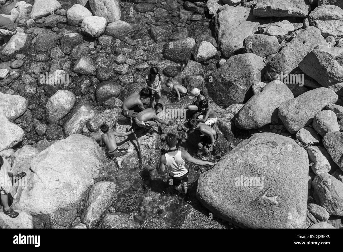 Yosemite Park, USA - July 22, 2008:  tourists cool their legs in the lake of the lower Yosemite waterfall in Yosemite, USA. In 1890, the U.S. Congress Stock Photo