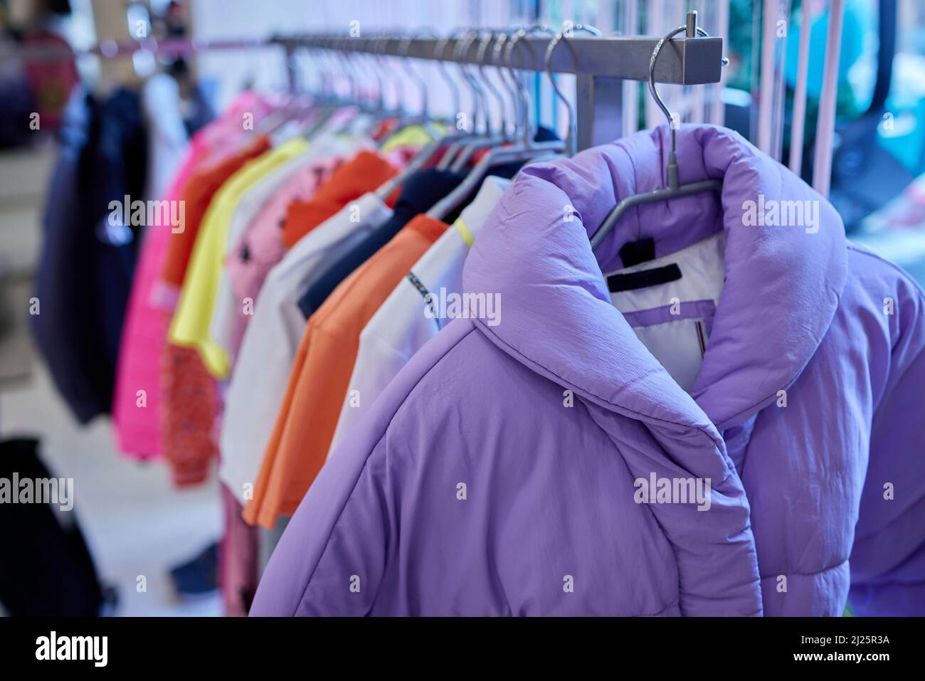 Fashion clothes on clothing rack, Bright colorful cotton shirts on hanger in boutique shop Stock Photo