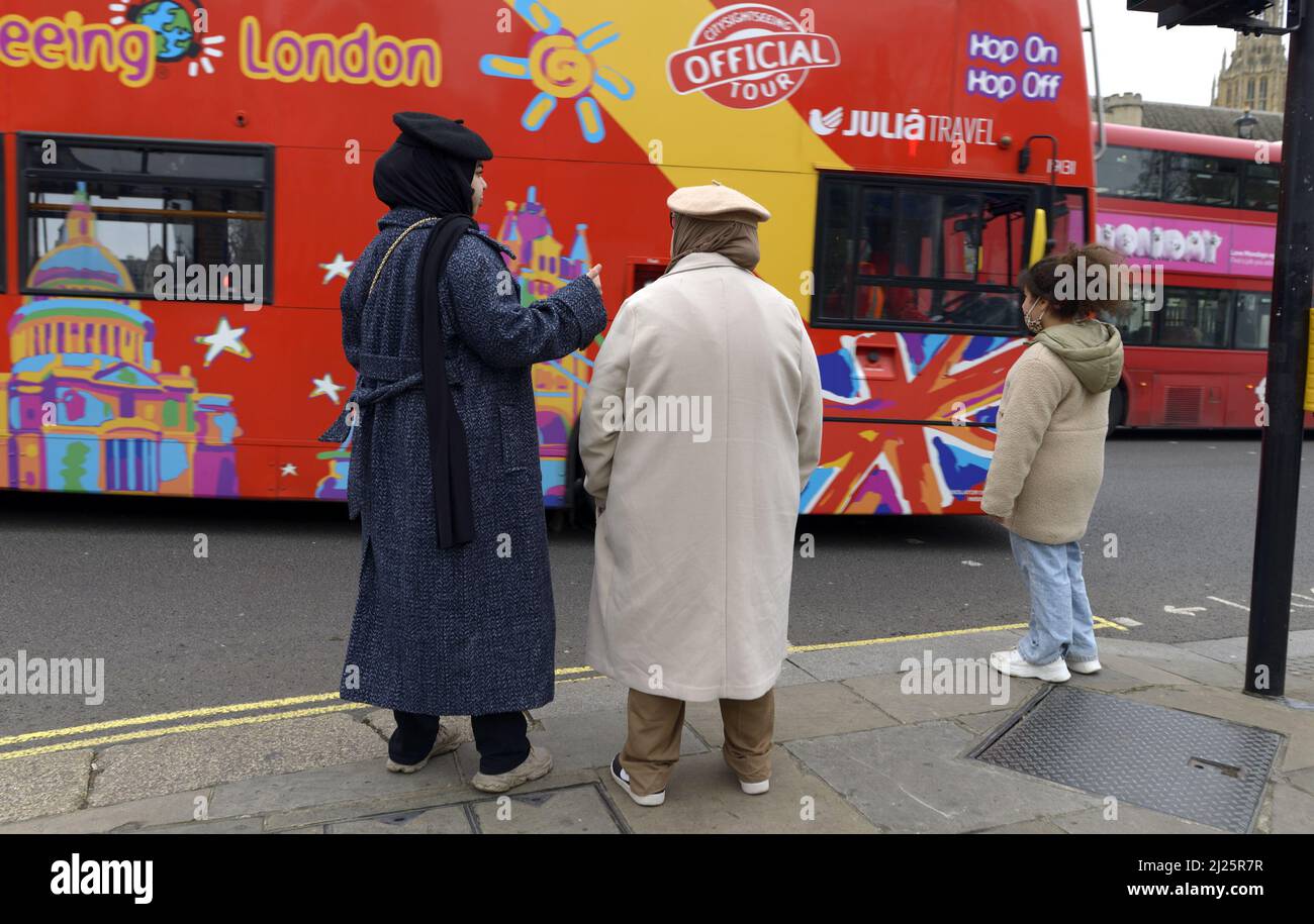 London, England, UK. Women wearing headscarves and berets and a young girl in Parliament Square - tourist bus going past Stock Photo
