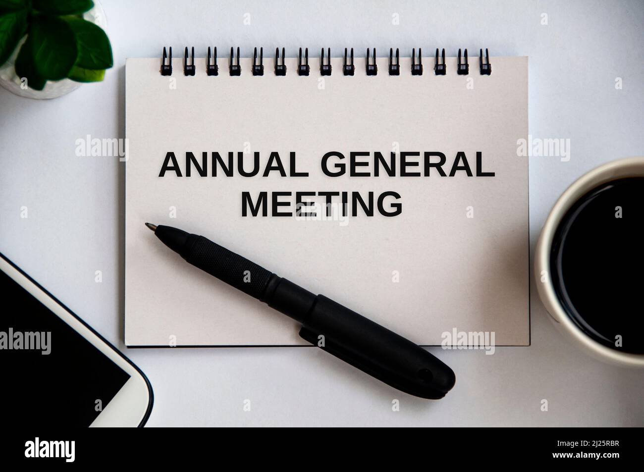 Annual general meeting text on notepad with office concept background. Stock Photo