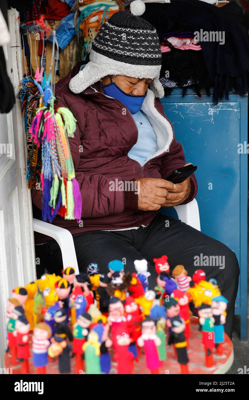 Shopkeeper using a cell phone in Riobamba, Ecuador Stock Photo Alamy