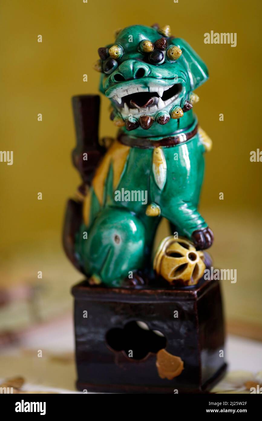 Green Chinese Dragon Figurine Holding a Ball in His Claws. Stock Photo