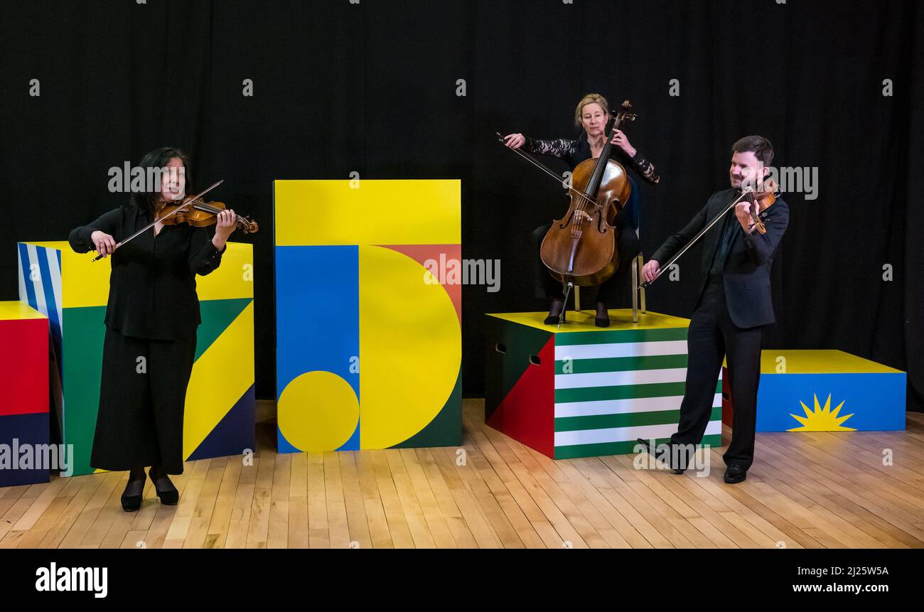 Leith, Edinburgh, UK, Scotland, 30 March 2022. Edinburgh International Festival launch: Musicians from Royal Scottish National Orchestra play music to launch the festival with from L to R Felix Tanner (violinist), Betsy Taylor (cellist) and Maya Iwabuchi (violinist) Stock Photo