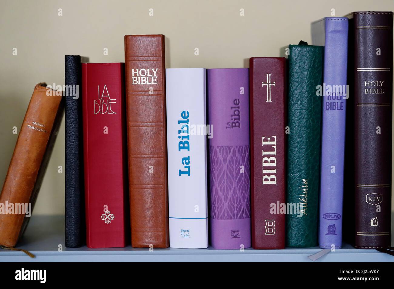 Christian bibles of different versions on a bookshelf. Religious symbol
