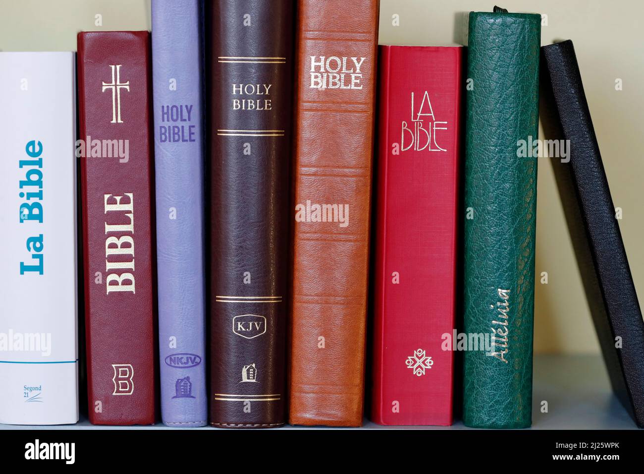Christian bibles of different versions on a bookshelf. Religious symbol