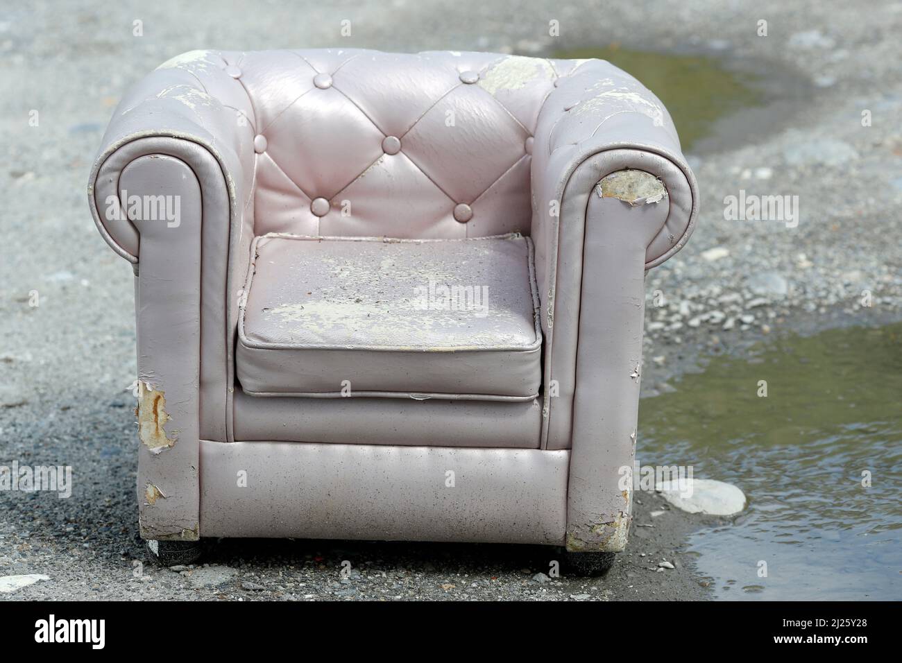Old chair left on country side road. Garbage. Stock Photo